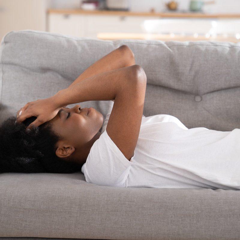 Woman Lying on Couch with a Headache