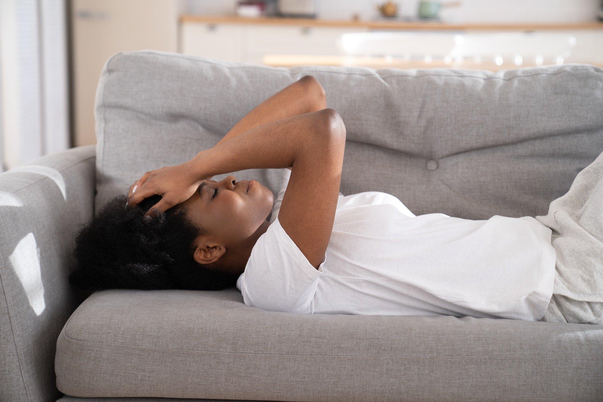 Woman Lying on Couch with a Headache